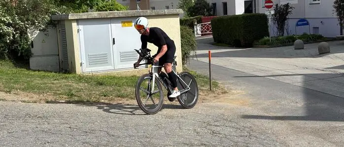 Ein Mann fährt auf einem schwarzen Rennrad