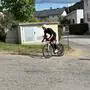 Ein Mann fährt auf einem schwarzen Rennrad