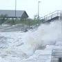 Local residents Portia Potyok, left, and Bradley Darby, watch the wind and waves along a seawall as outer bands of Hurricane Ida arrive Sunday, Aug. 29, 2021, in Bay Saint Louis, Miss. (AP Photo/Steve Helber)