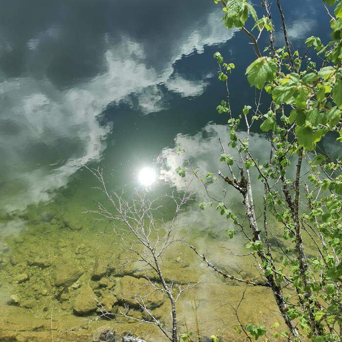 Perfekte Spiegelung | Im glasklaren Wasser des Altausseer Sees spiegeln sich Sonne und Wolken.