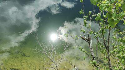Perfekte Spiegelung | Im glasklaren Wasser des Altausseer Sees spiegeln sich Sonne und Wolken.