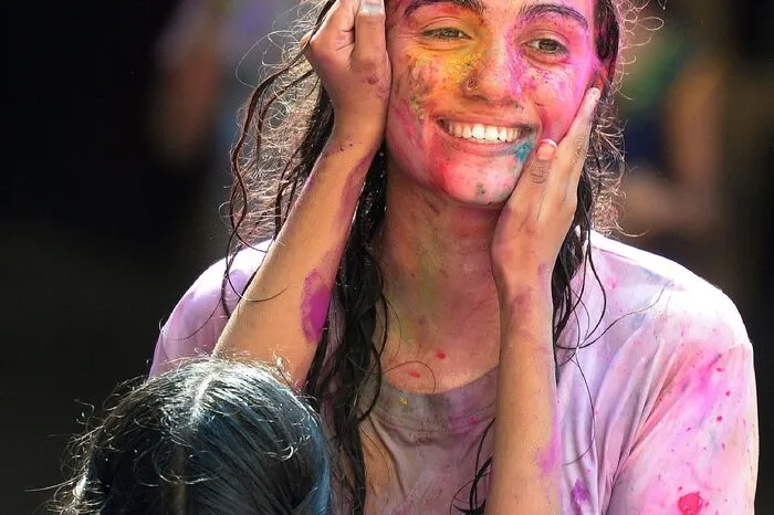 Frauen bekommen die Farbe ins Gesicht gestrichen.