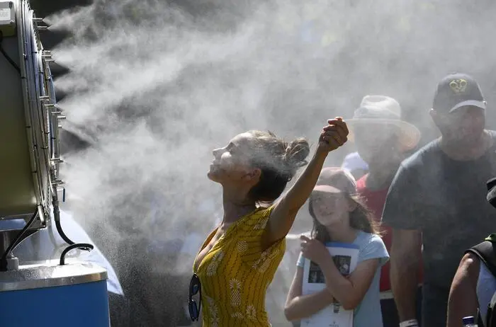 In this Jan. 14, 2019, file photo, spectators cool themselves down with a water mist fan during play on day one at the Australian Open tennis championships in Melbourne, Australia. Australia has sweltered through its hottest month on record in January and the summer of extremes continues with wildfires razing the drought-parched south while expanses of the tropical north are flooded. AustraliaâÄÖs Bureau of Meteorology confirmed the record heat during January as parts of the northern hemisphere have had record cold. (AP Photo/Andy Brownbill, File), sujet wetter, extreme hitze