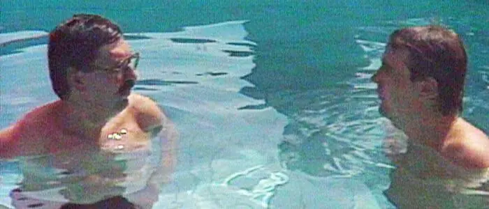 Zwei Männer stehen in einem Pool bis zur Brust im Wasser | 1981 gehen die Sommergespräche buchstäblich baden: ORF-Interviewer Peter Rabl bittet FPÖ-Chef Norbert Steger bei „brüllender Hitze“ in den Pool