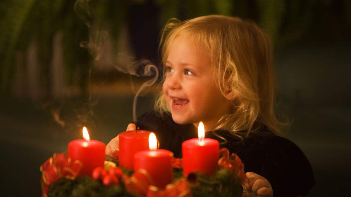 Kind mit Adventskranz zu Weihnachten