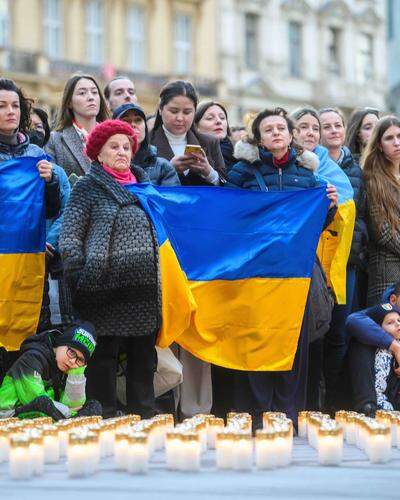 Menschen mit Ukraine-Flaggen vor einem „Lichtermeer“ aus Friedhofskerzen | Zehntausende Vertriebene leben aktuell in Österreich.