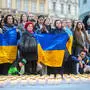 Menschen mit Ukraine-Flaggen vor einem „Lichtermeer“ aus Friedhofskerzen | Zehntausende Vertriebene leben aktuell in Österreich.
