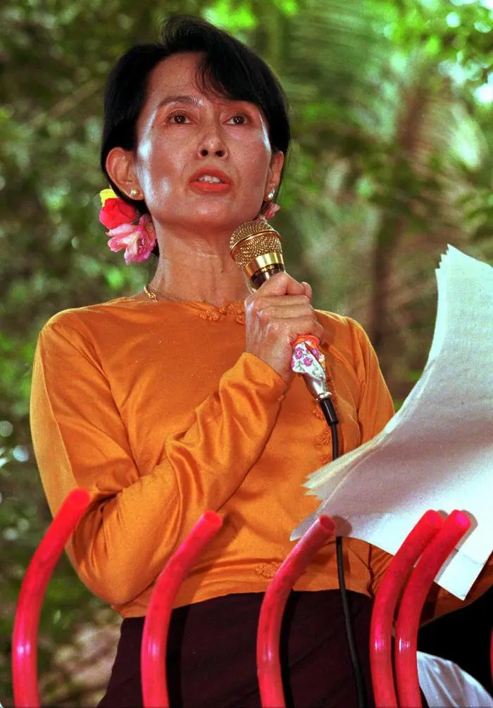 FILE--Burmese pro-democracy leader Aung San Suu Kyi gives a weekend speech to supporters from the gate of her residential compound in Rangoon , in this September 1, 1996 file photo. Nearly 200 riot police raided a roadside convoy and forced Aung San Suu Kyi to return to the capital, ending a nine-day standoff between the opposition leader and Myanmar's military regime, government and opposition party officials said Saturday September 2, 2000. (AP Photo/Richard Vogel)