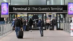 Holidaymakers and travellers arrive at Terminal 2 of London Heathrow Airport in west London, on April 6, 2022. British Airways on Wednesday cancelled 78 flights scheduled to land at, or take-off from, Heathrow Airport on Wednesday as staff shortages due to the Covid-19 pandemic continue to disrupt the aviation industry. (Photo by JUSTIN TALLIS / AFP)