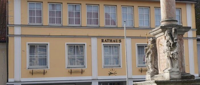Gelbes Radhaus, davor eine Säule