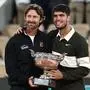 Juan Carlos Ferrero, Carlos Alcaraz | (FILES) Spain's Carlos Alcaraz poses with his Spanish coach Juan Carlos Ferrero (L) after winning against Italy's Jannik Sinner at the end of their men's singles final match on day 15 of the French Open tennis tournament on Court Philippe-Chatrier at the Roland-Garros Complex in Paris on June 8, 2025. Men's tennis world number one Carlos Alcaraz announced on December 17, 2025 on social media he is splitting from his coach Juan Carlos Ferrero after seven hugely successful years. (Photo by Thibaud MORITZ / AFP)