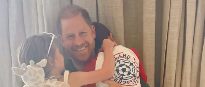Prinz Harry lächelt und umarmt dabei seine Kinder Archie und Lilibet