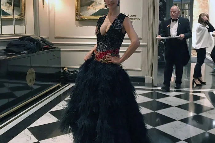 Iryna Tsymbal, Erste Solotänzerin der Wiener Staatsoper, in einer, im Oberteil all over handbestickten (Swarovski)- Kristallrobe mit einem tief angesetzten Anthrazit -schwarzem Federnrock.