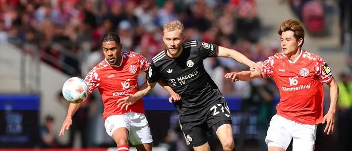 Bayerns Konrad Laimer im Duell mit  Phillipp Mwene (links) und Kaishu Sano