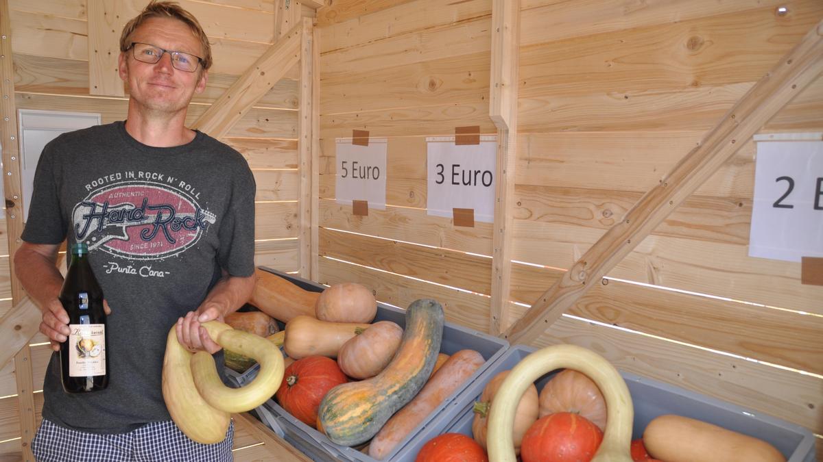 Landwirt Gerhard Stückler in seiner neuen „Kürbishütte“ mit einem Schlangenkürbis und dem selbst produzierten Kernöl in der Hand