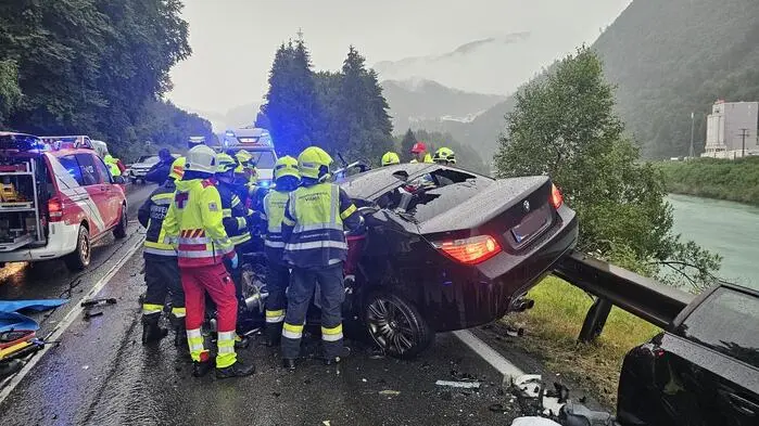 Man sieht ein Unfallwrack und viele Einsatzkräfte rundherum