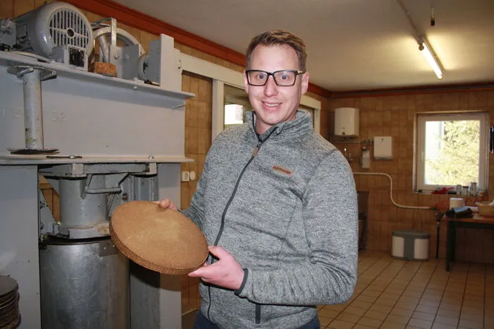 Robert Erschen junior mit einem sogenannten Presskuchen. Dieser bleibt nach dem Pressvorgang übrig, kann aber vielseitig weiterverwendet werden.