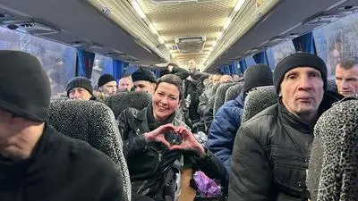 This handout photograph taken and released by the Coordination Headquarters for the Treatment of Prisoners of War on December 13, 2025, shows Belarusian opposition leader Maria Kalesnikava (C) making a heart sign with her hands as she sits in a bus among other former prisoners at an undisclosed location in Ukraine. Belarus has freed 123 prisoners, including protest leaders Viktar Babaryka, Maria Kalesnikava, and Nobel Peace Prize laureate Ales Bialiatski, rights groups and state media reported on December 13, 2025, after the US envoy earlier said Washington was lifting sanctions on Belarusian potassium. (Photo by Handout / COORDINATION HEADQUARTERS FOR THE TREATMENT OF PRISONERS OF WAR / AFP) / RESTRICTED TO EDITORIAL USE - MANDATORY CREDIT "AFP PHOTO / COORDINATION HEADQUARTERS FOR THE TREATMENT OF PRISONERS OF WAR" -  HANDOUT - NO MARKETING NO ADVERTISING CAMPAIGNS - DISTRIBUTED AS A SERVICE TO CLIENTS - AFP CANNOT INDEPENDENTLY VERIFY THE AUTHENTICITY OR LOCATION, DATE, AND CONTENT OF THESE IMAGES. / 