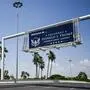 Straßenschild des „President Donald J. Trump International Airport“ über einem Highway.