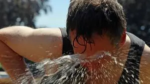 Ein Mann lässt sich Wasser ins Gesicht spritzen