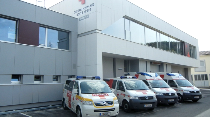 Zu sehen ist ein Gebäude mit zahlreichen Einsatzfahrzeugen 