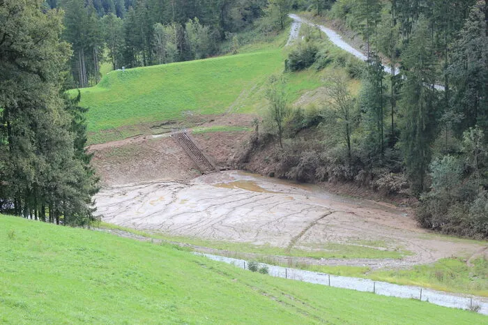 Gestern war das Rückhaltebecken vor allem mit Schlamm gefüllt, anhand der braunen Stellen ist zu erkennen, wie hoch das Wasser am Sonntagabend im Rückhaltebecken stand.