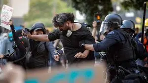 Police in riot gear grab a man during a protest following federal immigration operations in the Little Tokyo neighborhood of Los Angeles on June 9, 2025. President Donald Trump's administration said on June 9 that it was sending 700 US Marines and thousands more National Guard troops to Los Angeles, sparking a furious response from California's governor over the "deranged" deployment. (Photo by RINGO CHIU / AFP)