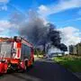 Ein Feuerwehrauto auf dem Weg zum Hamburger Hafen zu einem Brand. Im Hintergrund ist die dunkle Rauchwolke zu sehen. | Die dunkle Rauchwolke über dem Hamburger Hafen war kilometerweit zu sehen