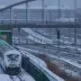 A Deutsche Bahn train (L) is seen in a depot close to Berlin's Ost Bahnhof railway station during snowfall in Berlin on February 8, 2021. - Snowfall, heavy gusts of wind and sub-zero temperatures in north and western Germany have caused travel interruptions on road and rail. (Photo by John MACDOUGALL / AFP)