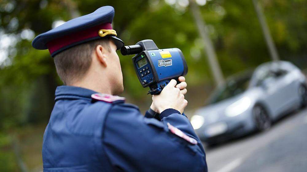 Symbolfoto: Polizist bei einer Geschwindigkeitskontrolle mit einem Radarmessgerät.