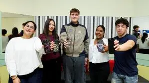 Das Bild zeigt Schülerinnen und Schüler der MedienHAK in Graz, die ihre Handys in die Kamera halten