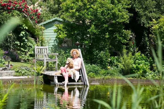 Andrea Urbanek und Königspudeldame Emmi am Naturteich im Aquilea Garten.
