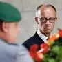 TOPSHOT - German Chancellor Friedrich Merz watches as soldiers carry a wreath on May 8, 2025 at Neue Wache in Berlin to commemorate the 80th anniversary of Germany's surrender on May 8, 1945 that ended the Second World War. (Photo by Odd ANDERSEN / AFP)