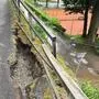 Ein Radweg ist abgerutscht, im Hintergrund sieht man einen Tennisplatz
