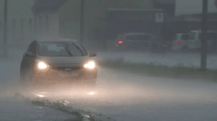 Bild zeigt Auto im Starkregen auf einer Straße