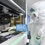 This photo taken on February 6, 2020 shows a laboratory technician working on samples from people to be tested for the new coronavirus at "Fire Eye" laboratory in Wuhan in China's central Hubei province. - BGI Group, a genome sequencing company based in southern China, said it opened on February 5 a lab in Wuhan able to test up to 10,000 people per day for the virus. The official Chinese death toll from the coronavirus outbreak rose on February 7 to 636, with the government saying total infections had climbed past 30,000. (Photo by STR / AFP) / China OUT