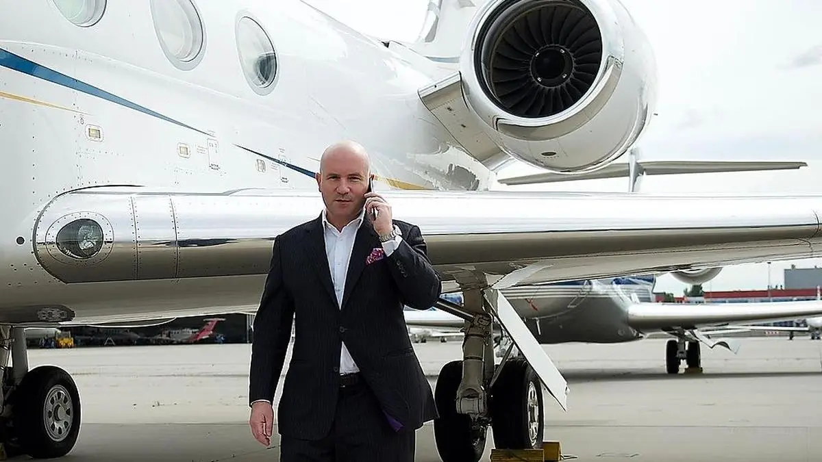 Florian Koschat telefonierend vor seinem Privatflugzeug