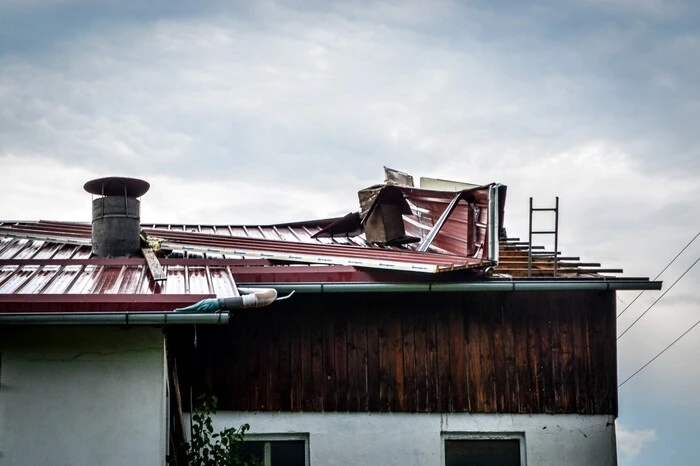 Mitglieder der Menschenrettung und Absturzsicherungseinheit stiegen gesichert auf die Dächer und diese wieder zu sichern und die abgedeckten Flächen mittels Planen abzudecken.