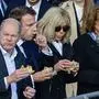 TOPSHOT - German Chancellor Olaf Scholz (L) and his wife Britta Ernst (R), French President Emmanuel Macron and French first lady Brigitte Macron (2ndR) eat a fish sandwich at a fish stall in Hamburg, northern Germany, on October 10, 2023, on the second day of two-day German-French government consultations. (Photo by John MACDOUGALL / AFP)