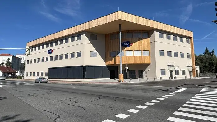 Außenansicht eines neu umgebauten zweistöckigen Gebäudes, davor ist eine Straße mit einem Zebrastreifen