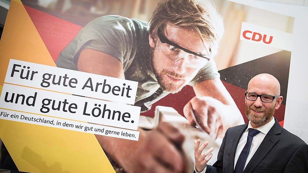 Peter Tauber vor einem Wahlplakat der CDU 