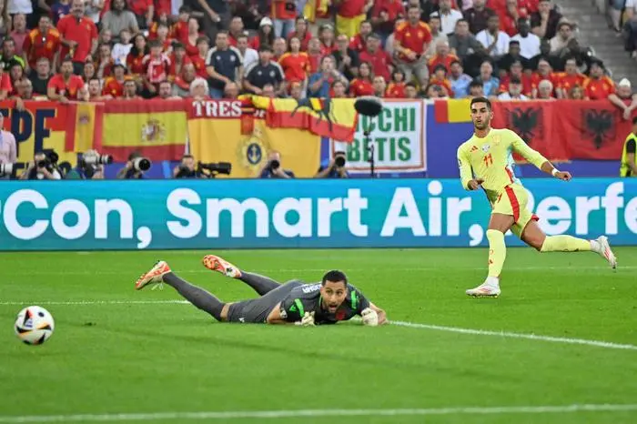 TOPSHOT - Spain's forward #11 Ferran Torres (R) scores his team's first goal past Albania's goalkeeper #23 Thomas Strakosha during the UEFA Euro 2024 Group B football match between Albania and Spain at the Duesseldorf Arena in Duesseldorf on June 24, 2024. (Photo by INA FASSBENDER / AFP)