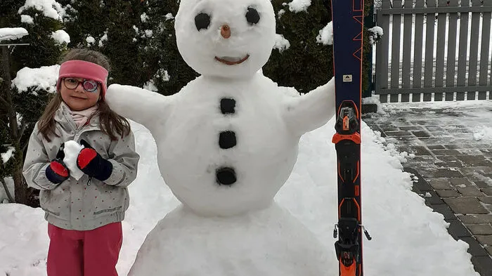 Laura mit ihrem Schneemann, den sie gemeinsam mit Opa in Apfelberg gebaut hat.