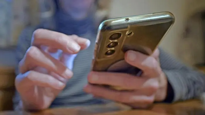 Eine Frau hält ein Telefon in ihrer Hand