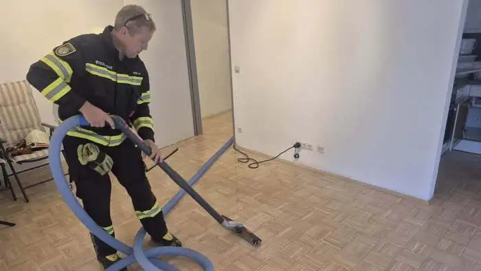 Ein Feuerwehrmann beim Entfernen des stehenden Wassers