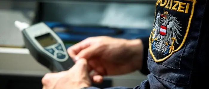 Ein Alkomat wird von einem Polizisten in Händen gehalten