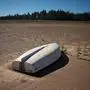 TOPSHOT - A picture taken on May 10, 2017 shows a boat lying on the sand at the Theewaterskloof Dam, which has less than 20% of it's water capacity, near Villiersdorp, about 108 km from Cape Town. 
This dam is the main water source for the city of Cape Town, and there is only 10% of it's usual capacity left for human consumption, at the last 10% is not useable, due to the silt content. The Western Cape Province, which includes Cape Town is suffering from one of the worst water shortages in living memory. This has necessitated the Cape Town City Councel to establish stringent water usage restrictions, and unless unexpectedly heavy rains fall soon, the province will begin a cycle of drought. / AFP PHOTO / Rodger BOSCH