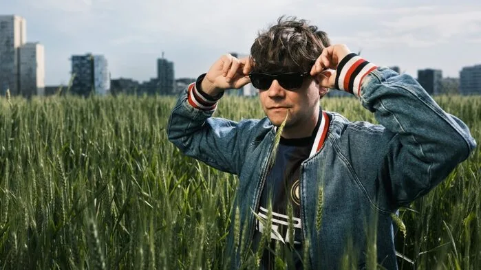 Ein Mann mit Sonnenbrille steht im hohen Gras