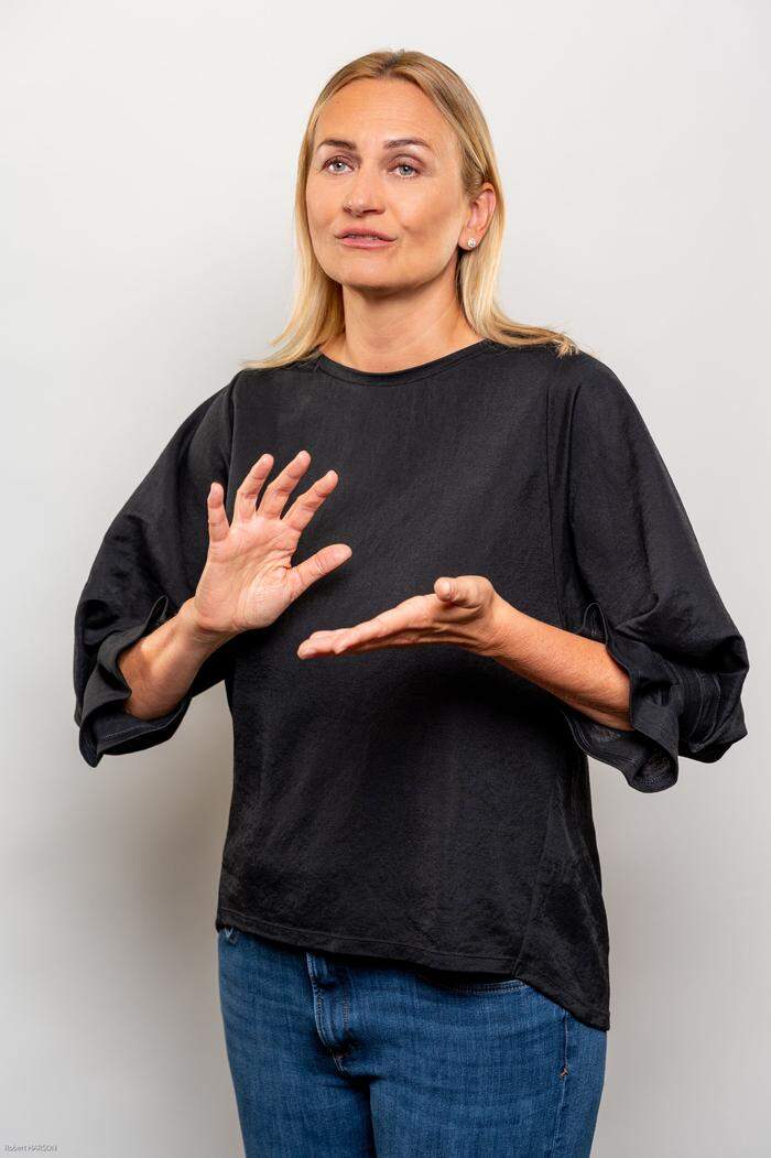 Helene Jarmer ist Präsidentin des Österreichischen Gehörlosenbundes, sie zeigt das Wort "Gebärdensprache"