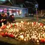People lay candles near the Le Constellation bar, where a devastating fire left dead and injured during the New Year's celebrations in Crans-Montana, Swiss Alps, Switzerland, Thursday, Jan. 1, 2026. (AP Photo/ Antonio Calanni)